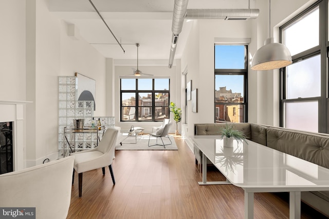 living area featuring a towering ceiling, a fireplace, and wood finished floors