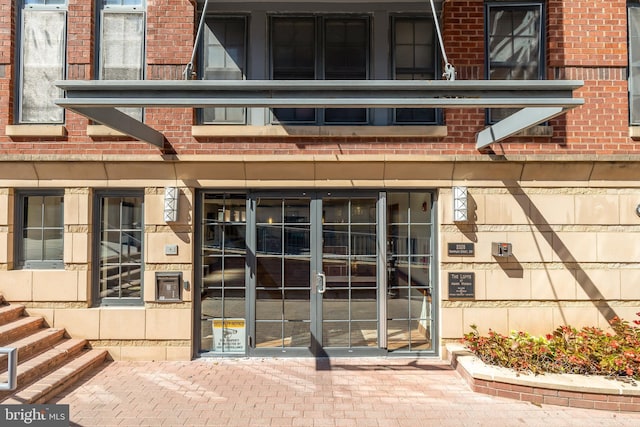 entrance to property featuring brick siding