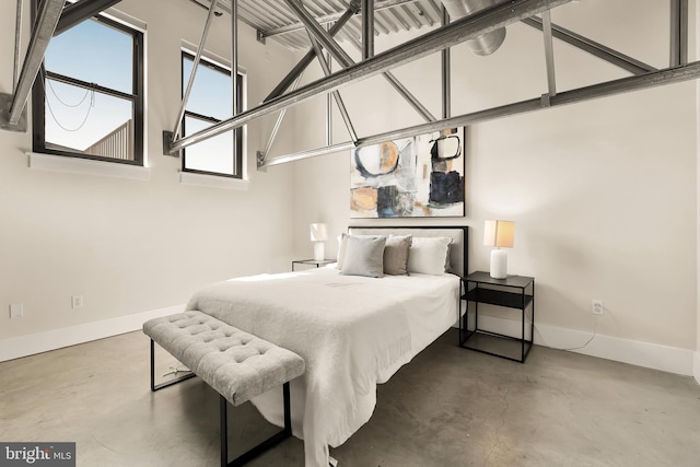 bedroom with concrete flooring and baseboards