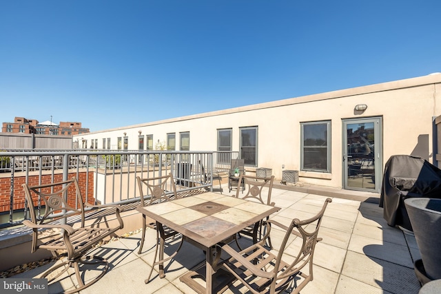 view of patio featuring outdoor dining space, grilling area, and a balcony