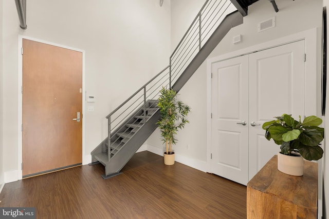 foyer featuring stairway, wood finished floors, visible vents, and baseboards