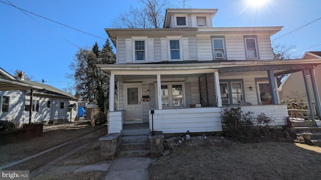 american foursquare style home featuring a porch