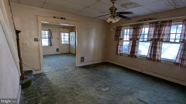 unfurnished dining area featuring visible vents, baseboards, ceiling fan, carpet, and a paneled ceiling