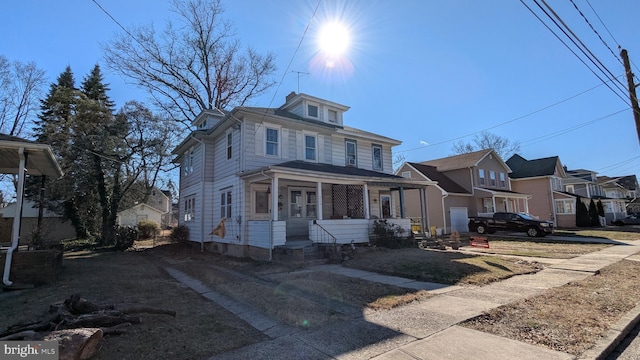 american foursquare style home with covered porch and a residential view