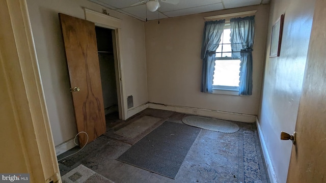 unfurnished bedroom with a drop ceiling, visible vents, and baseboards