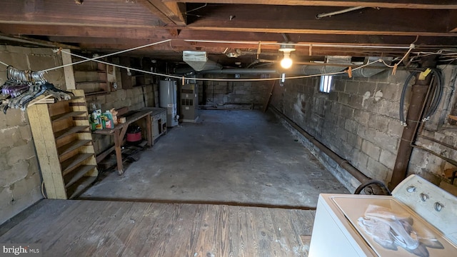 basement featuring water heater, washer / clothes dryer, and wood finished floors