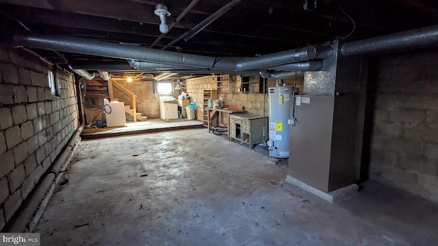 below grade area featuring water heater, stairway, and separate washer and dryer