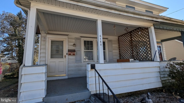 view of exterior entry featuring covered porch