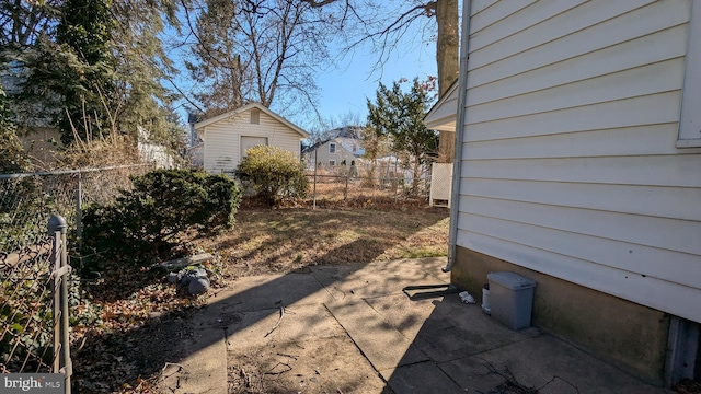 view of yard with a storage shed, a patio, an outdoor structure, and fence