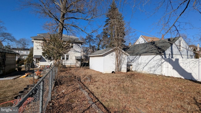 exterior space with a storage shed, an outbuilding, and a fenced backyard