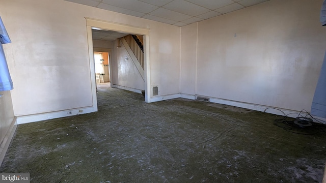 unfurnished room with stairway, baseboards, visible vents, and a drop ceiling