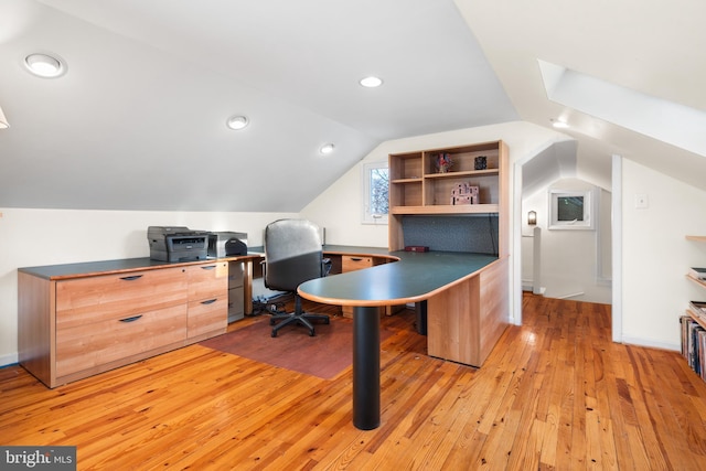 home office featuring light wood finished floors, vaulted ceiling with skylight, baseboards, and recessed lighting