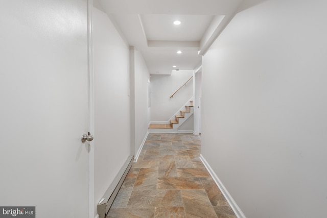 corridor featuring baseboards, stairway, stone finish floor, a baseboard heating unit, and recessed lighting