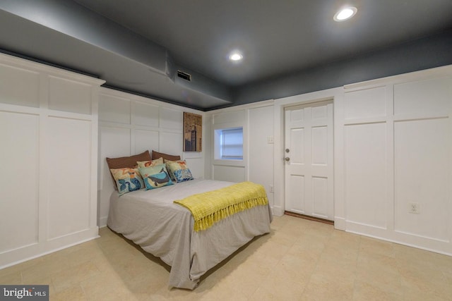 bedroom featuring recessed lighting, visible vents, and a decorative wall