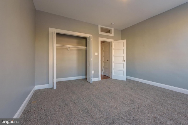 unfurnished bedroom with carpet floors, a closet, and baseboards