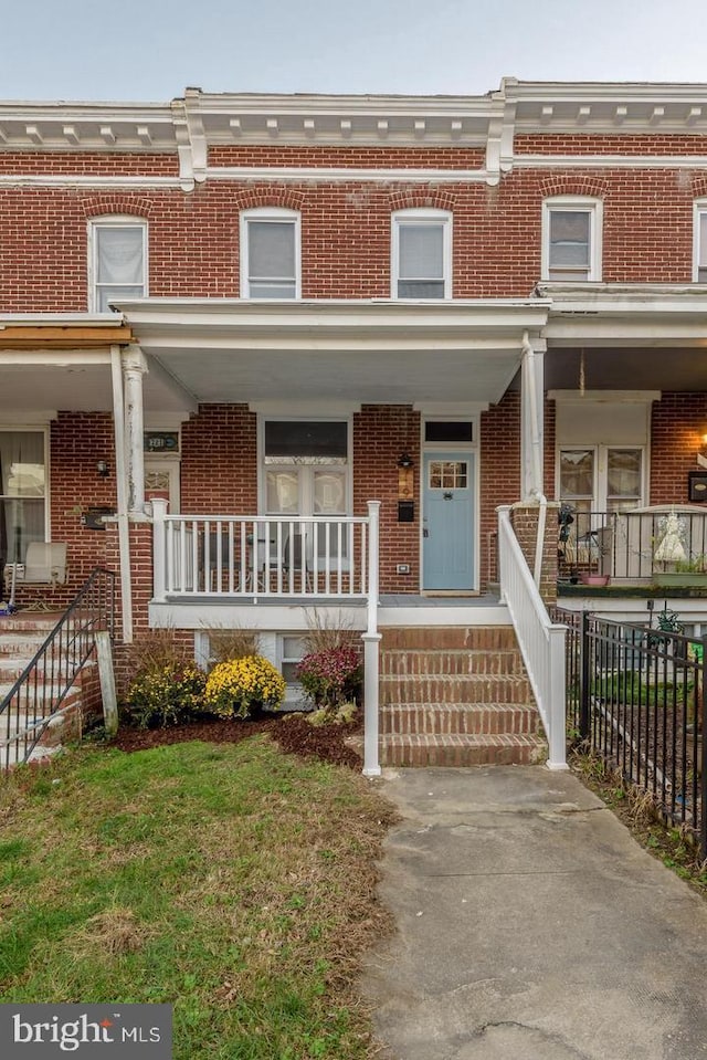 view of property with a porch and brick siding