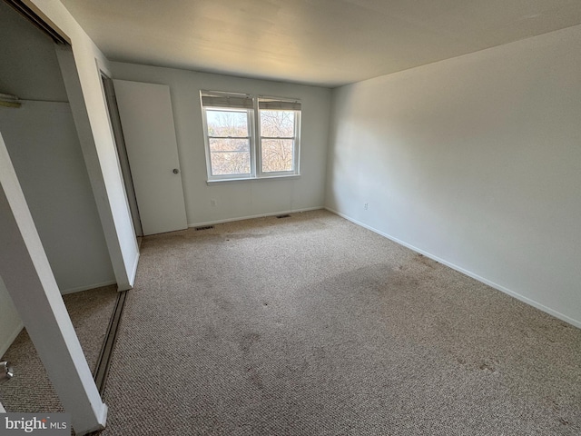 unfurnished bedroom featuring carpet floors, visible vents, and baseboards