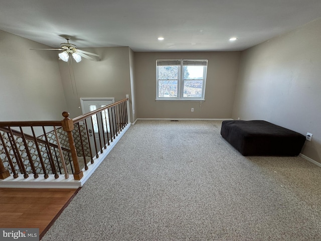 unfurnished room featuring carpet, recessed lighting, ceiling fan, an upstairs landing, and baseboards