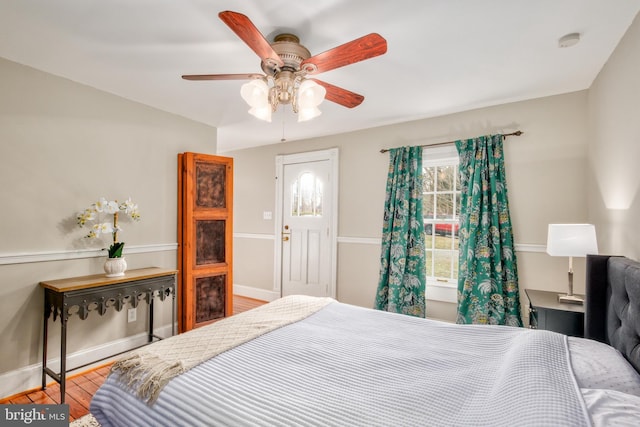 bedroom with ceiling fan, wood finished floors, and baseboards