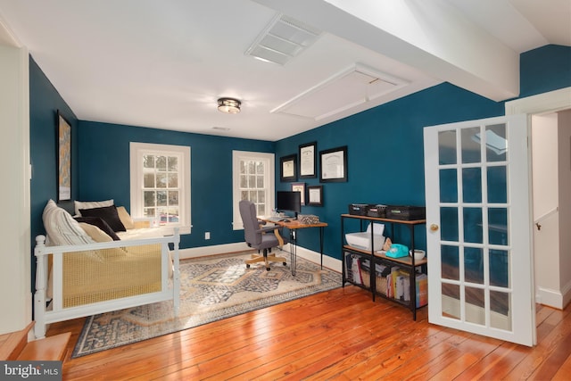 office area with lofted ceiling, baseboards, visible vents, and hardwood / wood-style floors