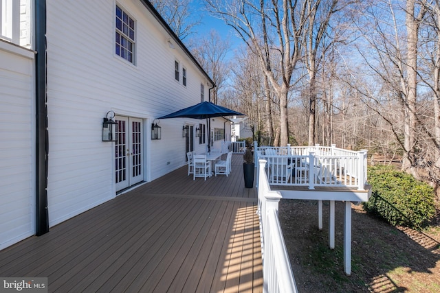 wooden terrace featuring french doors and outdoor dining area