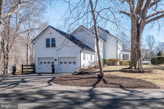 view of home's exterior with driveway and fence