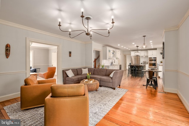 living room featuring light wood-type flooring, stairs, and ornamental molding