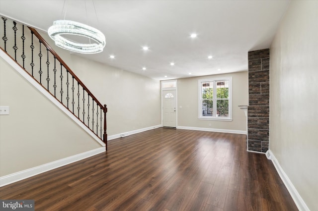 entrance foyer with dark wood finished floors, recessed lighting, an inviting chandelier, baseboards, and stairs