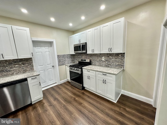 kitchen featuring stainless steel appliances, white cabinetry, light stone counters, and dark wood-type flooring