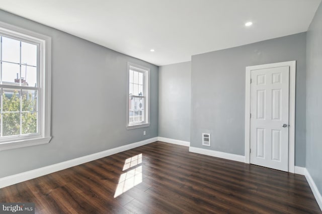 unfurnished room with baseboards, dark wood finished floors, and recessed lighting