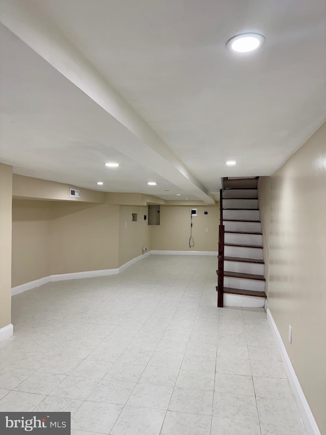 finished below grade area featuring recessed lighting, visible vents, baseboards, stairway, and tile patterned floors