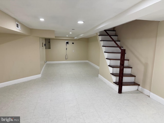 finished basement featuring stairway, recessed lighting, electric panel, and baseboards