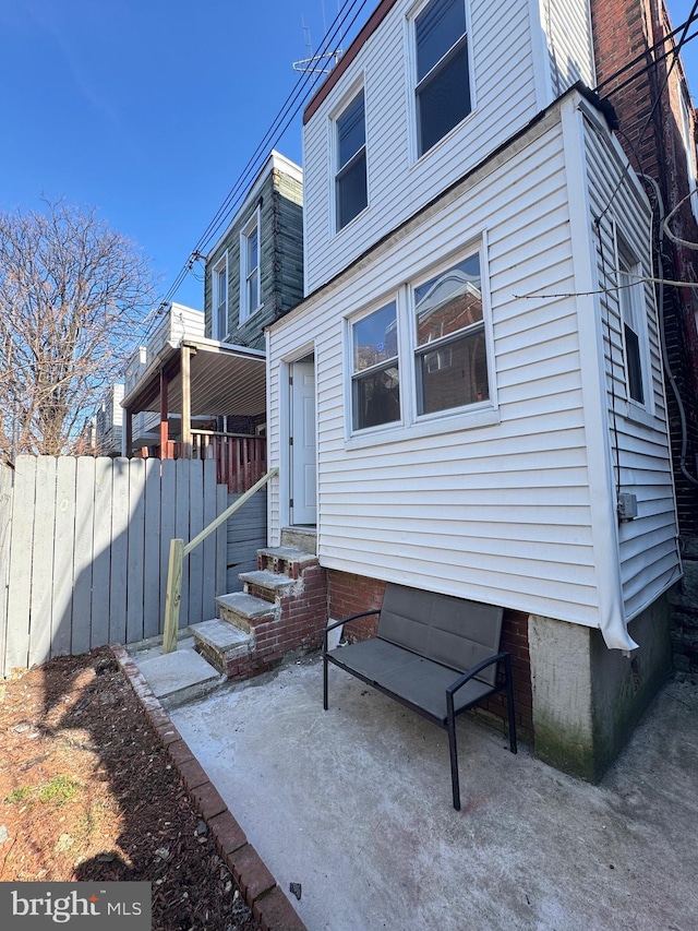 exterior space with entry steps, a patio, and fence