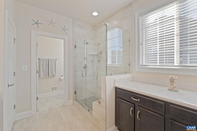 bathroom featuring a shower stall, visible vents, and baseboards