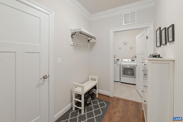 laundry area with laundry area, separate washer and dryer, wood finished floors, visible vents, and crown molding