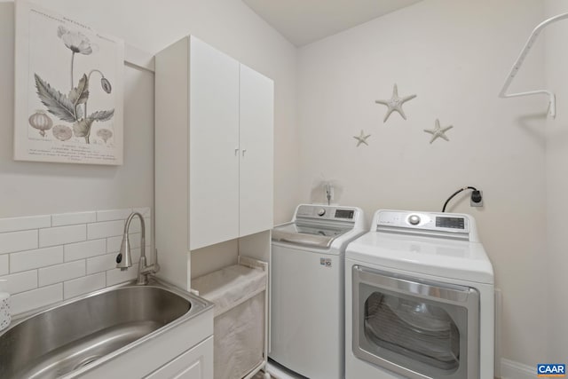 washroom featuring washing machine and clothes dryer, a sink, and cabinet space