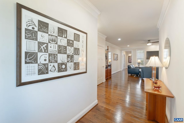 hall featuring baseboards, recessed lighting, hardwood / wood-style flooring, and crown molding