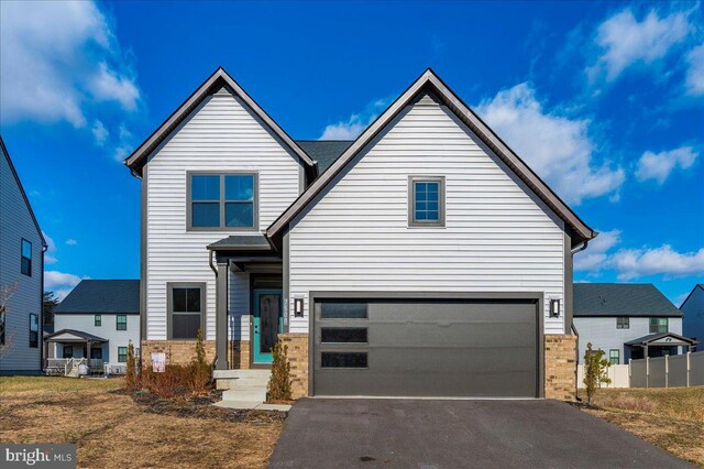 view of front facade featuring driveway, an attached garage, and brick siding