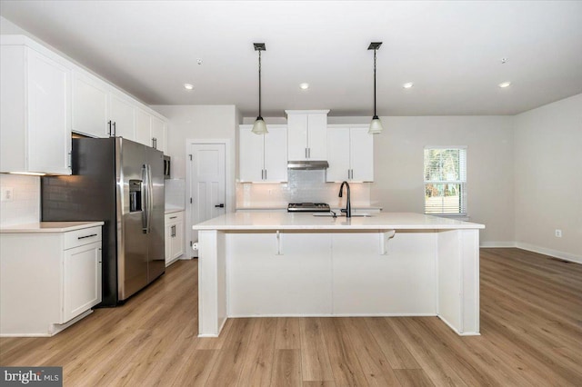 7508 Blue Sun Dr, Glen Burnie, MD 21060 - kitchen with light wood-style floors, stainless steel fridge, a sink, and under cabinet range hood