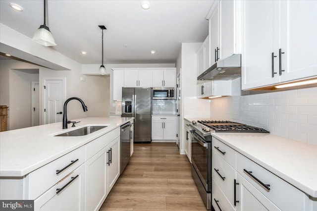 7508 Blue Sun Dr, Glen Burnie, MD 21060 - kitchen with under cabinet range hood, white cabinetry, stainless steel appliances, and a sink