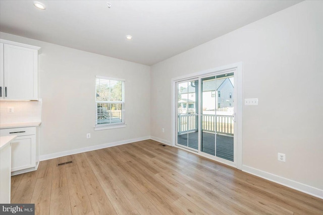 7508 Blue Sun Dr, Glen Burnie, MD 21060 - unfurnished dining area featuring a healthy amount of sunlight, light wood finished floors, baseboards, and visible vents