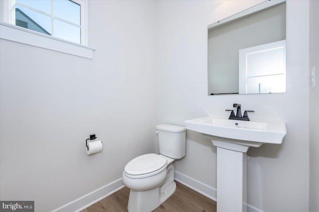 7508 Blue Sun Dr, Glen Burnie, MD 21060 - half bath featuring toilet, baseboards, and wood finished floors