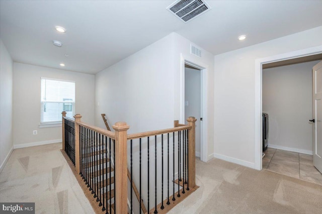 7508 Blue Sun Dr, Glen Burnie, MD 21060 - hallway featuring light colored carpet, baseboards, visible vents, and an upstairs landing