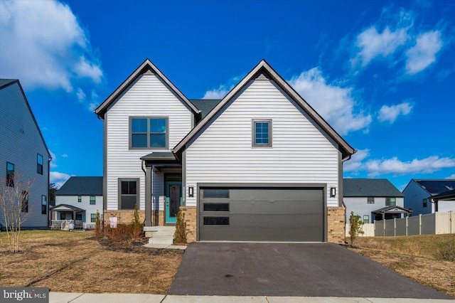 7508 Blue Sun Dr, Glen Burnie, MD 21060 - view of front facade featuring driveway, stone siding, an attached garage, and fence