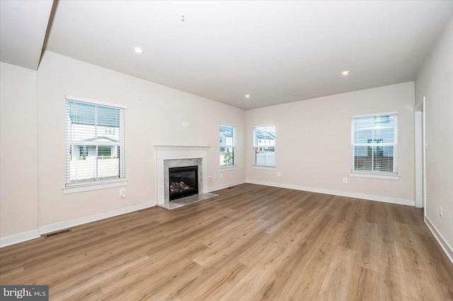 7508 Blue Sun Dr, Glen Burnie, MD 21060 - unfurnished living room with light wood-style floors, a high end fireplace, visible vents, and baseboards