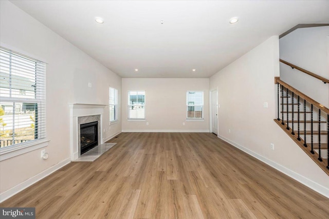 7508 Blue Sun Dr, Glen Burnie, MD 21060 - unfurnished living room with a high end fireplace, baseboards, stairway, and light wood finished floors