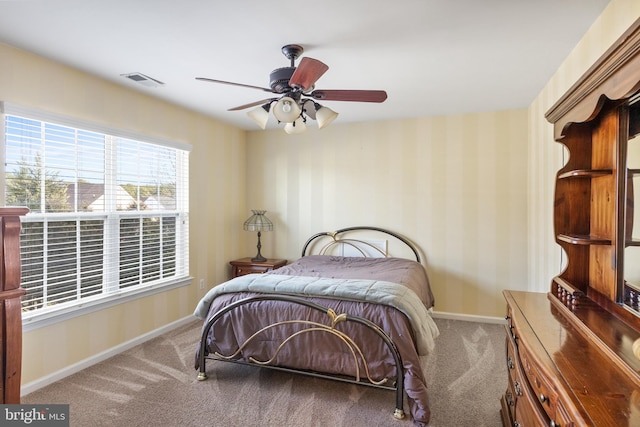 bedroom featuring visible vents, light carpet, ceiling fan, baseboards, and wallpapered walls