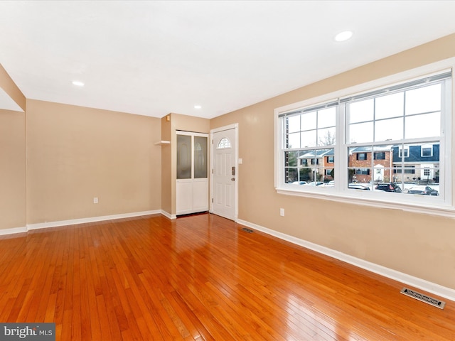 interior space featuring baseboards, visible vents, and hardwood / wood-style floors