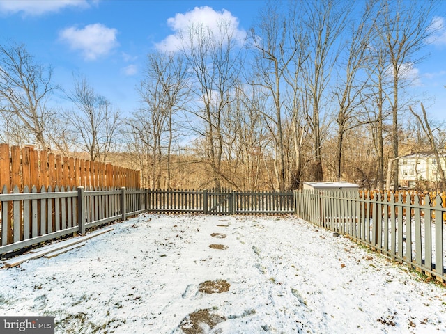 yard covered in snow with a fenced backyard