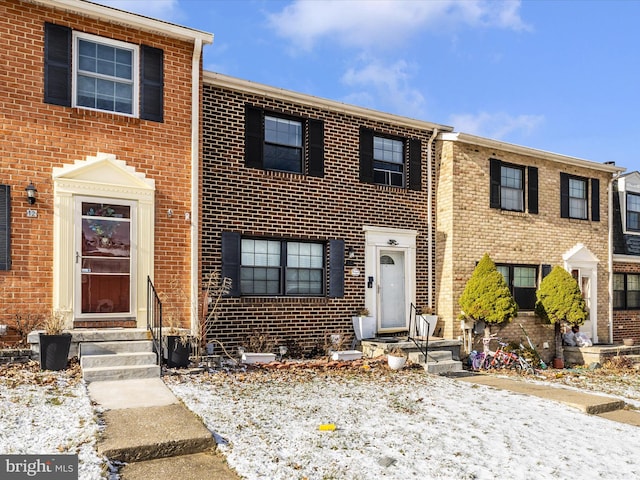 townhome / multi-family property featuring entry steps and brick siding